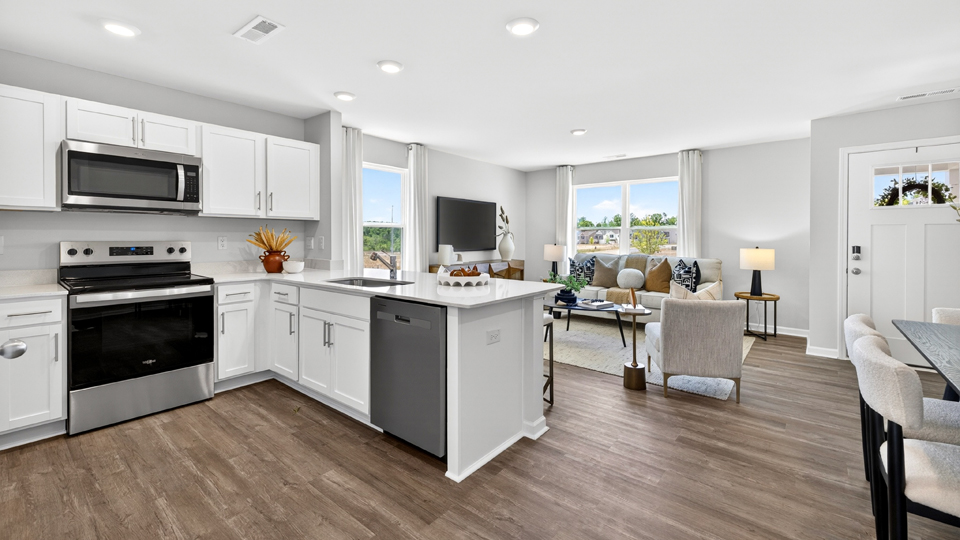 kitchen with quartz counters, kitchen peninsula, pantry, stainless steel appliances