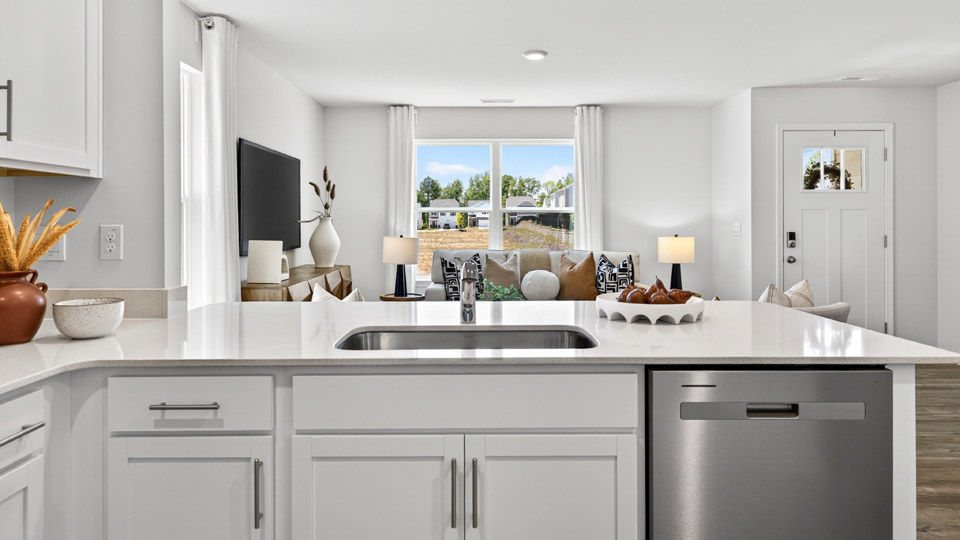 kitchen with quartz counters, kitchen peninsula, pantry, stainless steel appliances