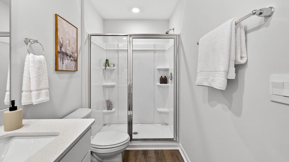 primary bathroom with walk in shower and dual vanity sinks
