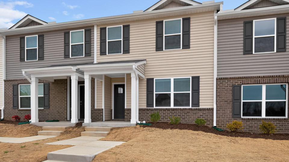Two story town home with yellow siding.