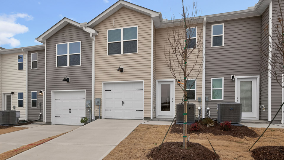 Two story town home with yellow siding & garage