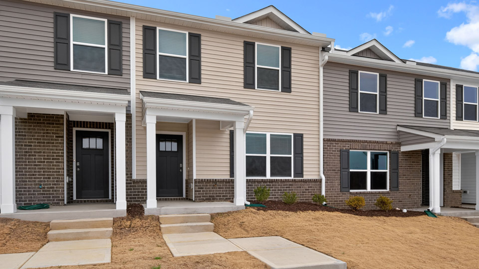 Two story town home with yellow siding.