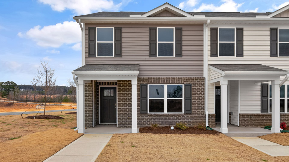 Two story town home with brown siding.