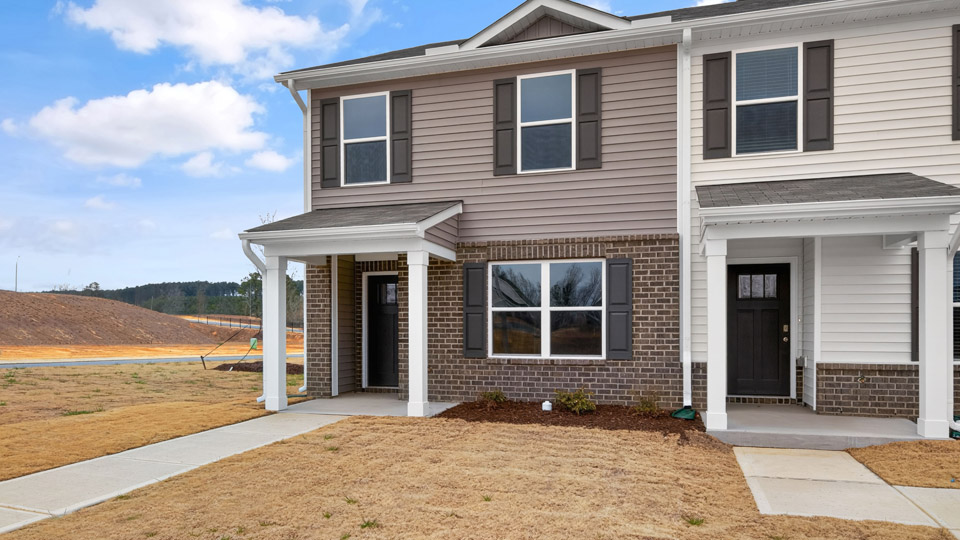 Two story town home with brown siding.