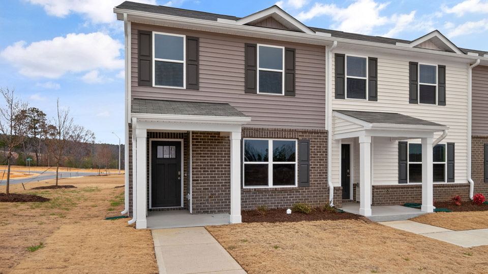 Two story town home with brown siding.