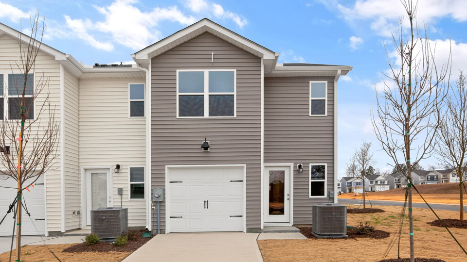 Two story town home with brown siding & garage