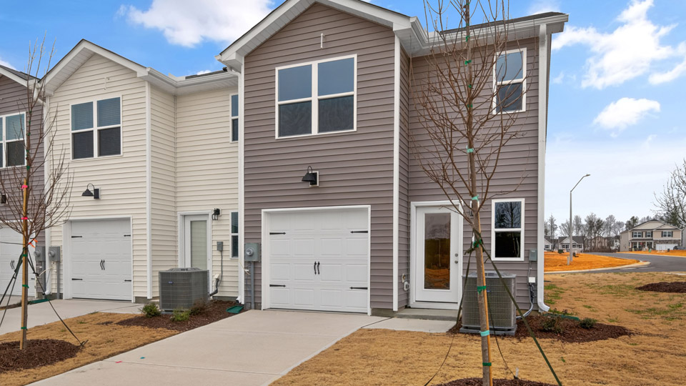 Two story town home with brown siding & garage