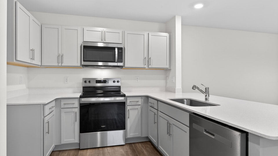 Kitchen with gray cabinets and stainless steel appliances.