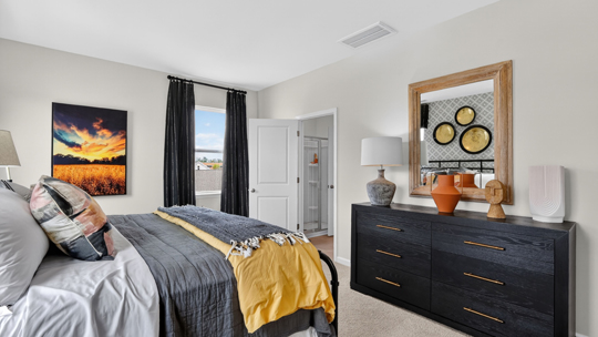 primary bedroom with two windows and carpeting, attached bath