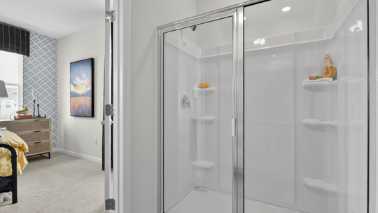 primary bathroom with walk in shower and dual vanity sinks