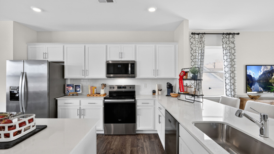 kitchen with white cabinets quarttz countertops and stainless steel appliances