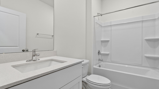 bathroom with quartz countertops and tub shower combo