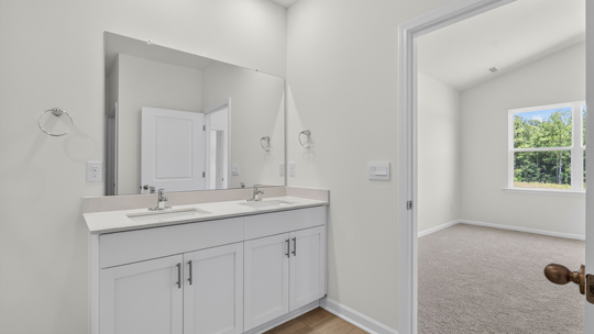 bathroom with dual vanity and quartz countertops