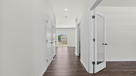 foyer entryway with revwood flooring and study on right