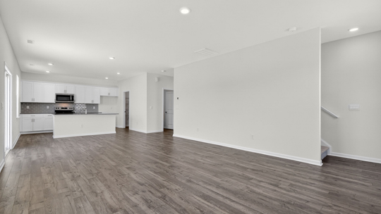 open concept living room overlooked by kitchen