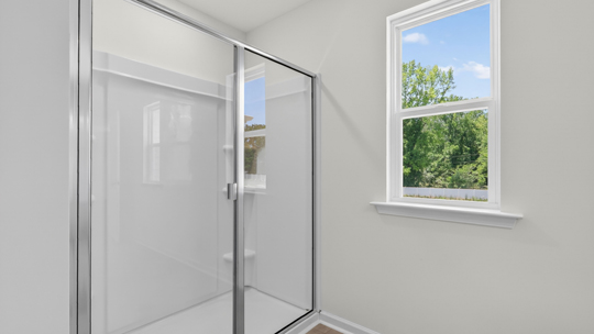 bathroom with walkin shower and window