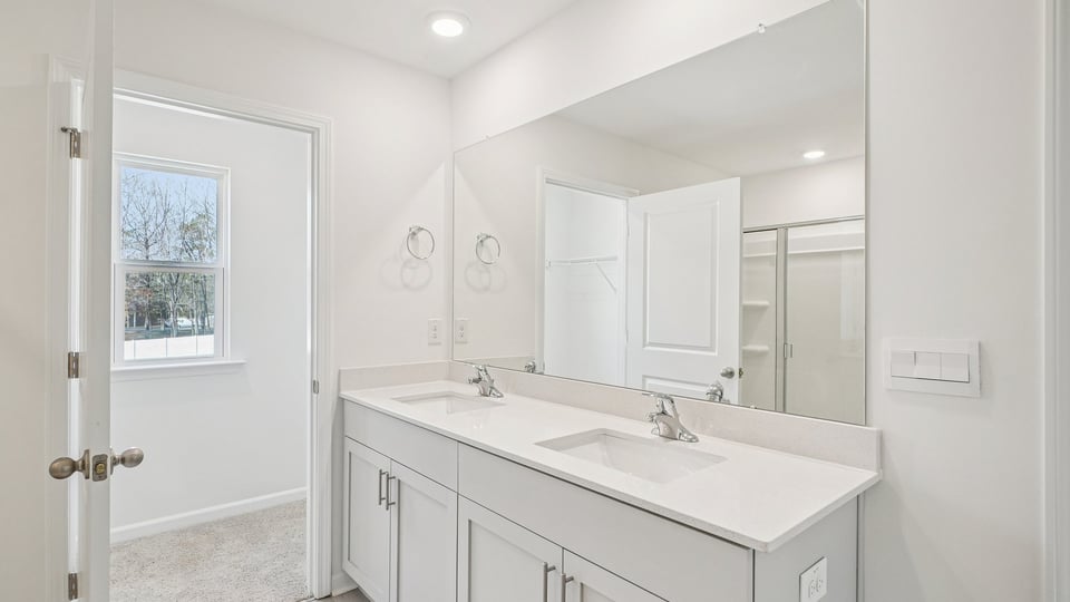 bathroom with dual vanity and quartz countertops