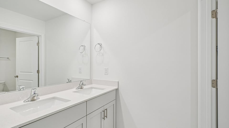 bathroom with dual vanity and quartz countertops