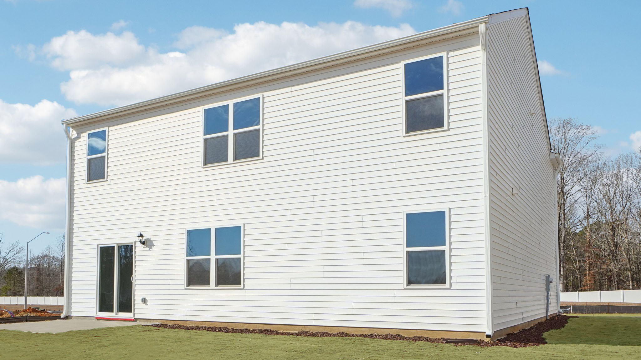 back of home with concrete patio