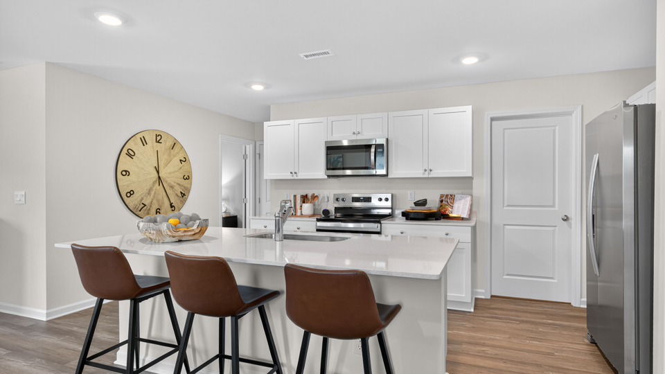 kitchen with white cabinets quartz countertops and revwood flooring