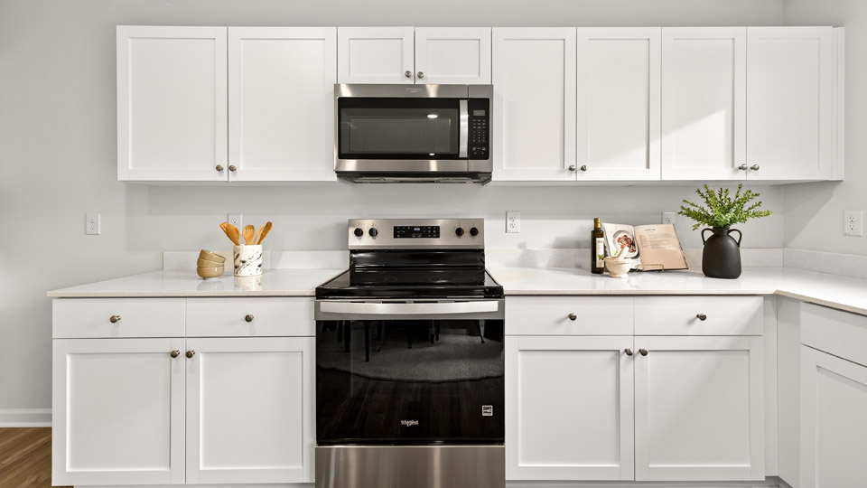 kitchen with white cabinets quartz countertops and stainless steel appliances