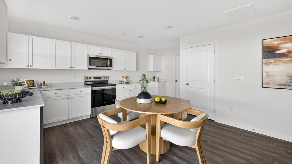 kitchen with white cabinets quartz countertops and dining area