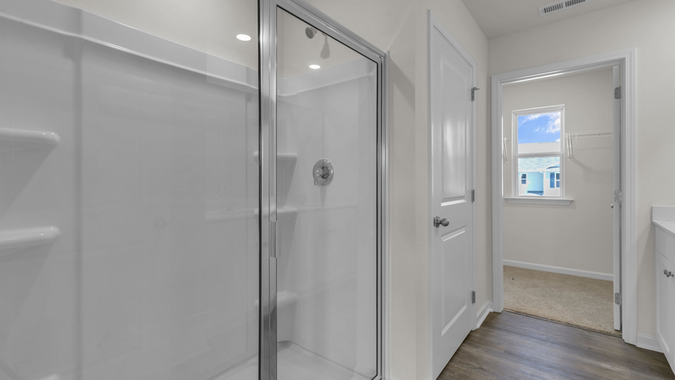 primary bathroom with walk in shower and dual vanity sinks