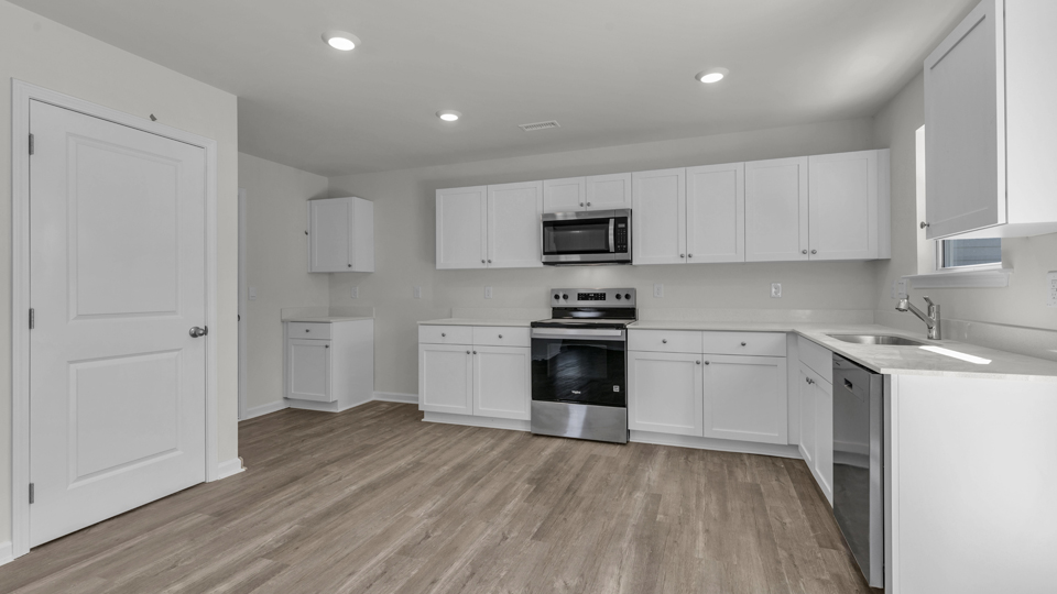 kitchen with quartz counters, kitchen island, pantry, stainless steel appliances