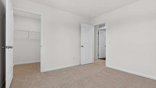bedroom with carpet flooring and walkin closet