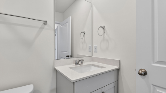 secondary bathroom with gray cabinets quartz countertops