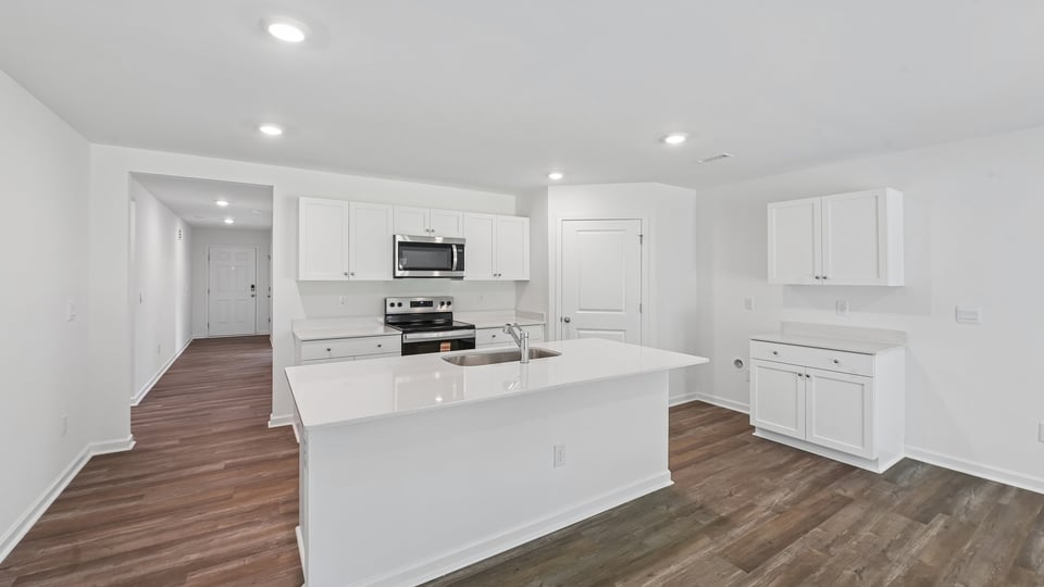 kitchen with white cabinets quartz countertops and spaicous island