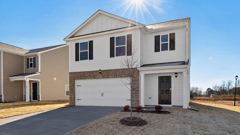 Two story home with white colored siding and front porch and a two car garage