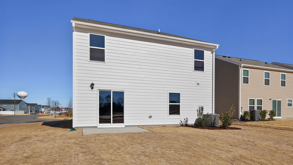 Two story home with white colored siding and back patio