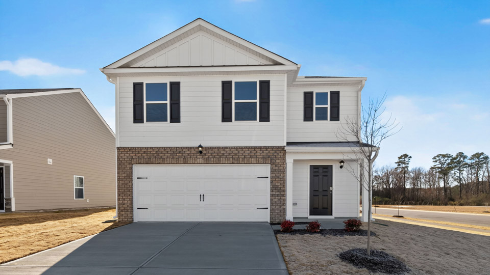 Two story home with white colored siding and front porch and a two car garage