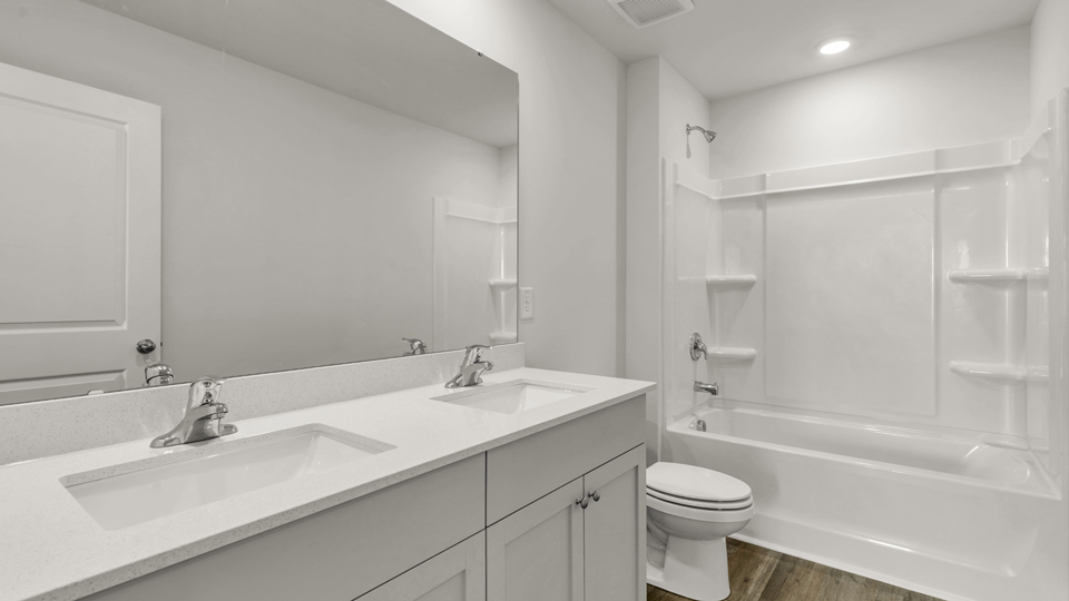 primary bathroom with walk in shower and dual vanity sinks