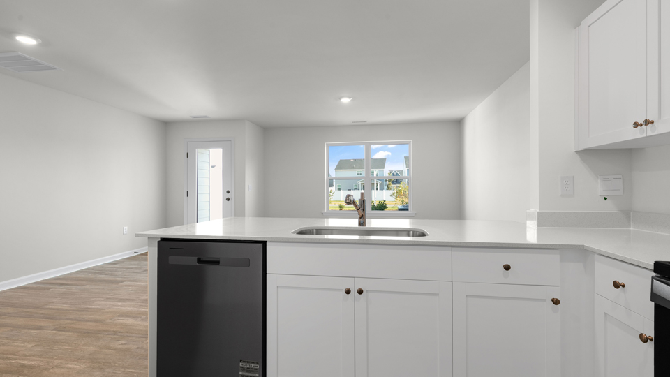 kitchen with quartz counters, kitchen island, pantry, stainless steel appliances