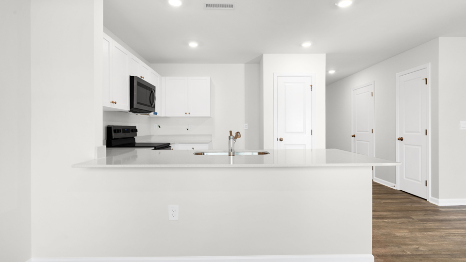 kitchen with quartz counters, kitchen island, pantry, stainless steel appliances