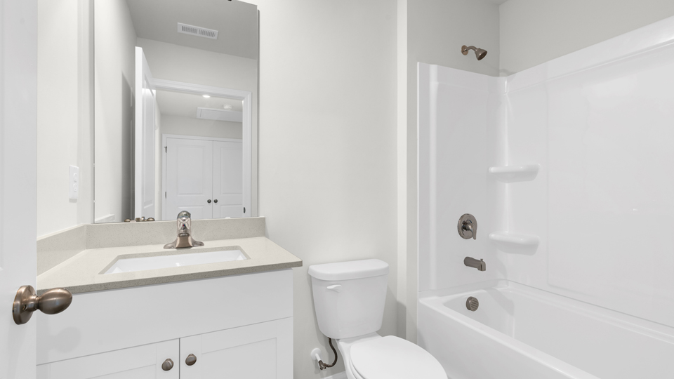 secondary bathroom with shower tub combo and single vanity sink