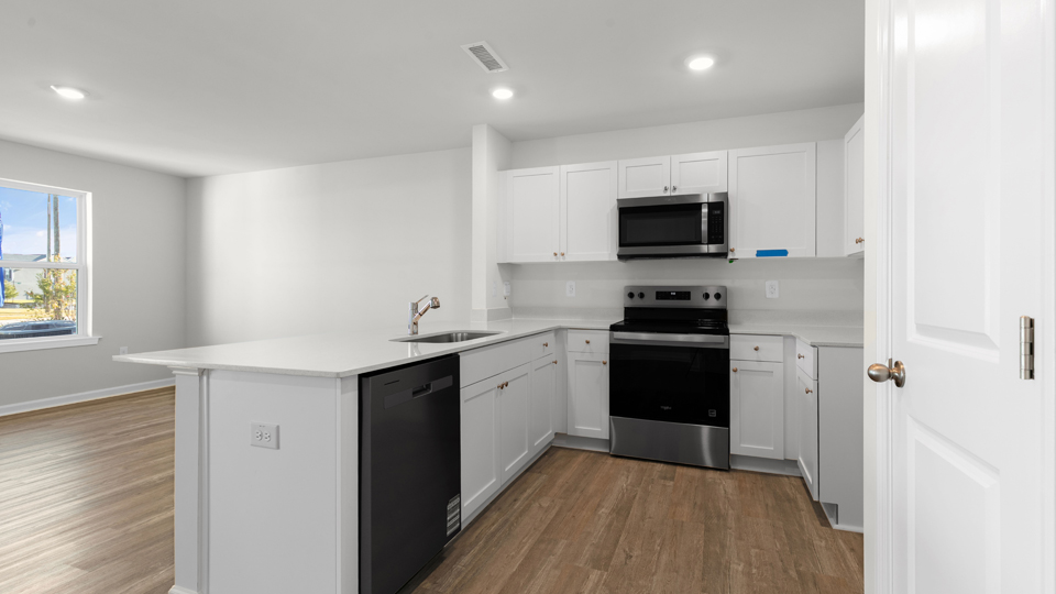 kitchen with quartz counters, kitchen island, pantry, stainless steel appliances