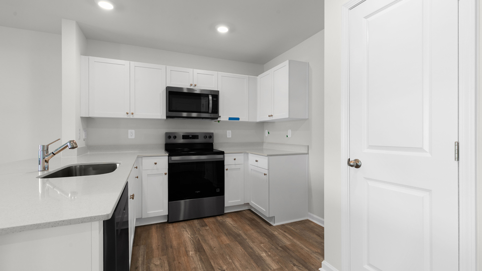 kitchen with quartz counters, kitchen island, pantry, stainless steel appliances
