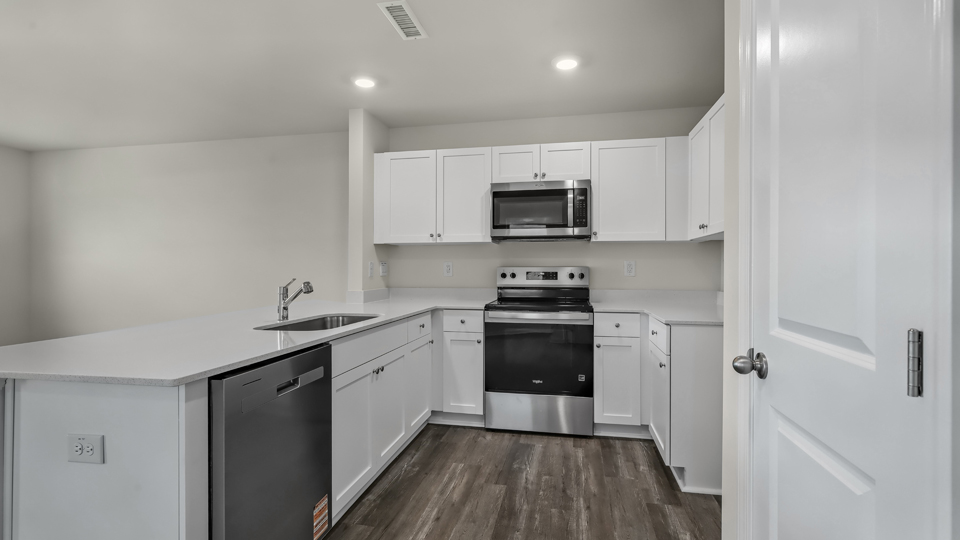 kitchen with quartz counters, kitchen island, pantry, stainless steel appliances