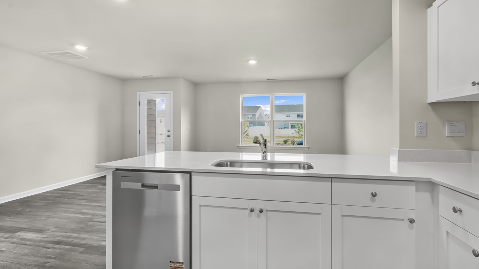 kitchen with quartz counters, kitchen island, pantry, stainless steel appliances