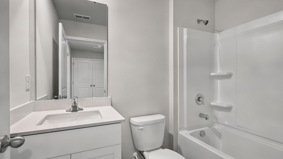 secondary bathroom with shower tub combo and single vanity sink