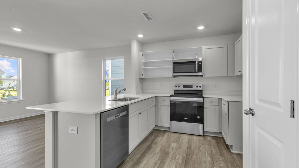kitchen with quartz counters, kitchen island, pantry, stainless steel appliances