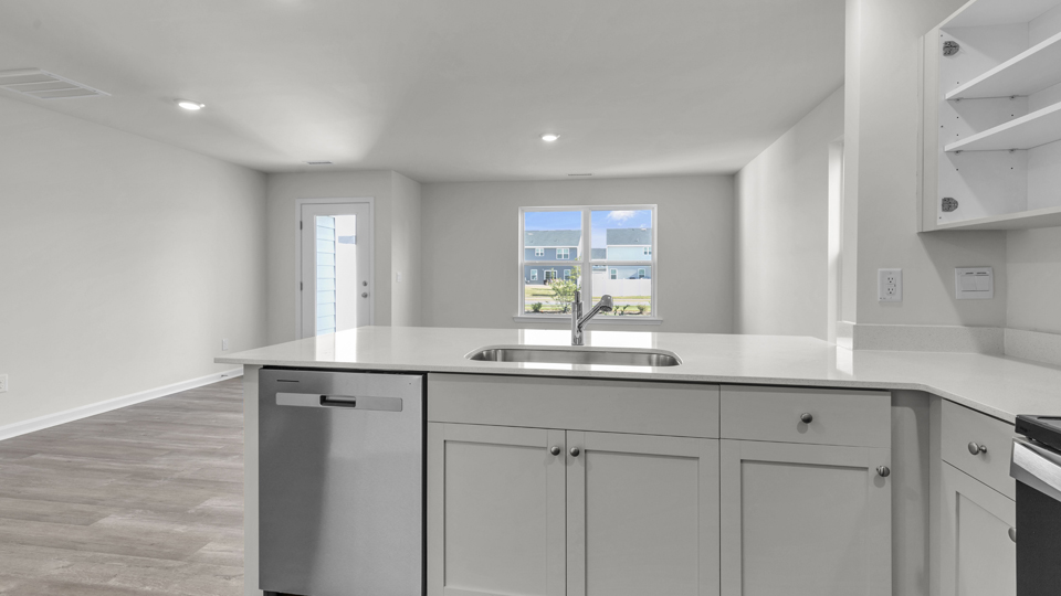 kitchen with quartz counters, kitchen island, pantry, stainless steel appliances