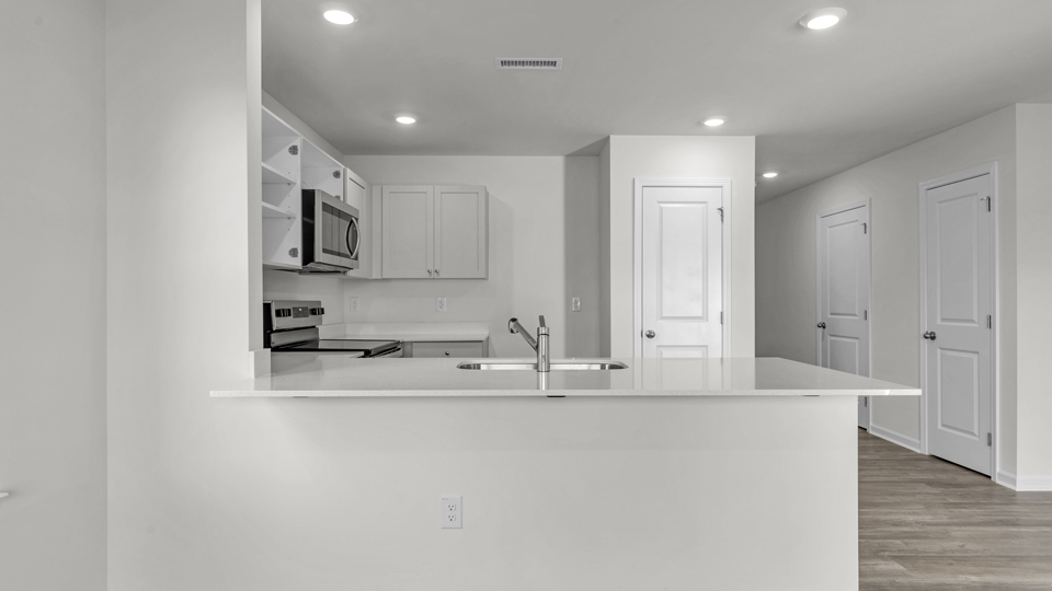 kitchen with quartz counters, kitchen island, pantry, stainless steel appliances