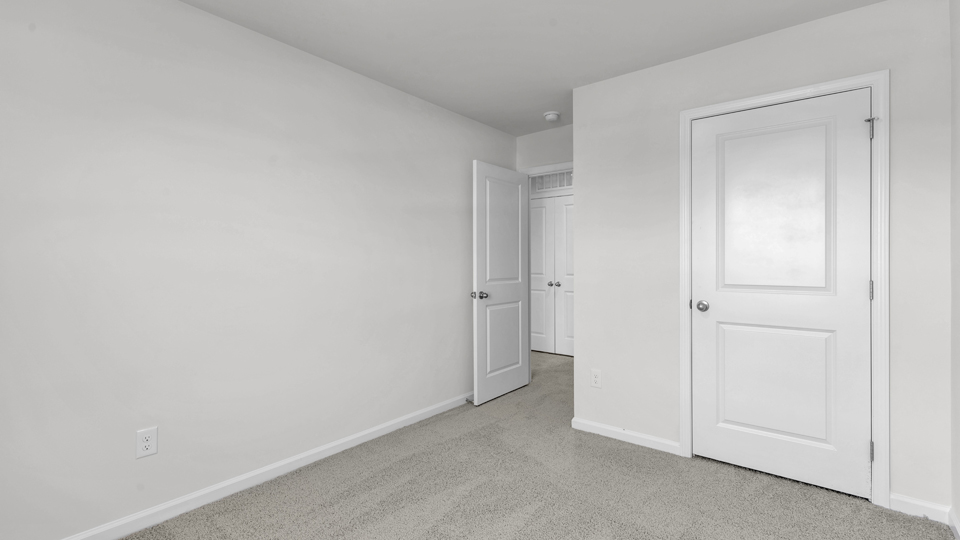 secondary bedroom with window and closet, carpeting