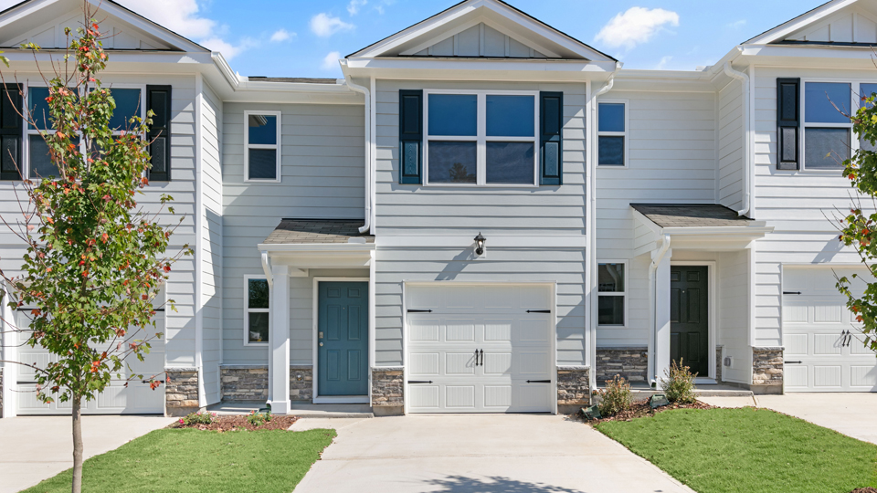 front exterior of Pearson A3, light gray and blue shutters, one car garage door with driveway