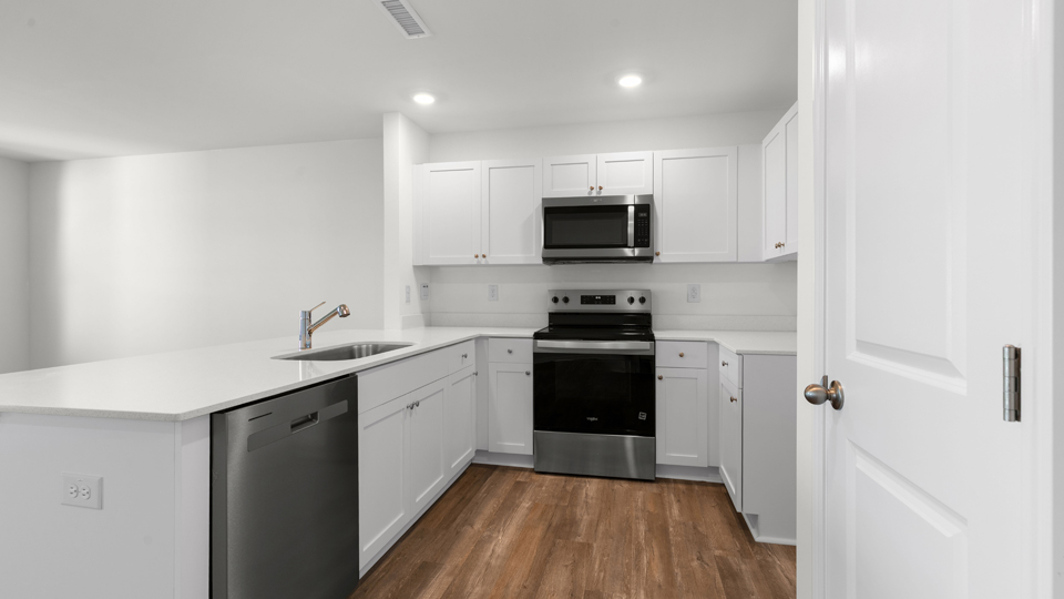 kitchen with quartz counters, kitchen island, pantry, stainless steel appliances