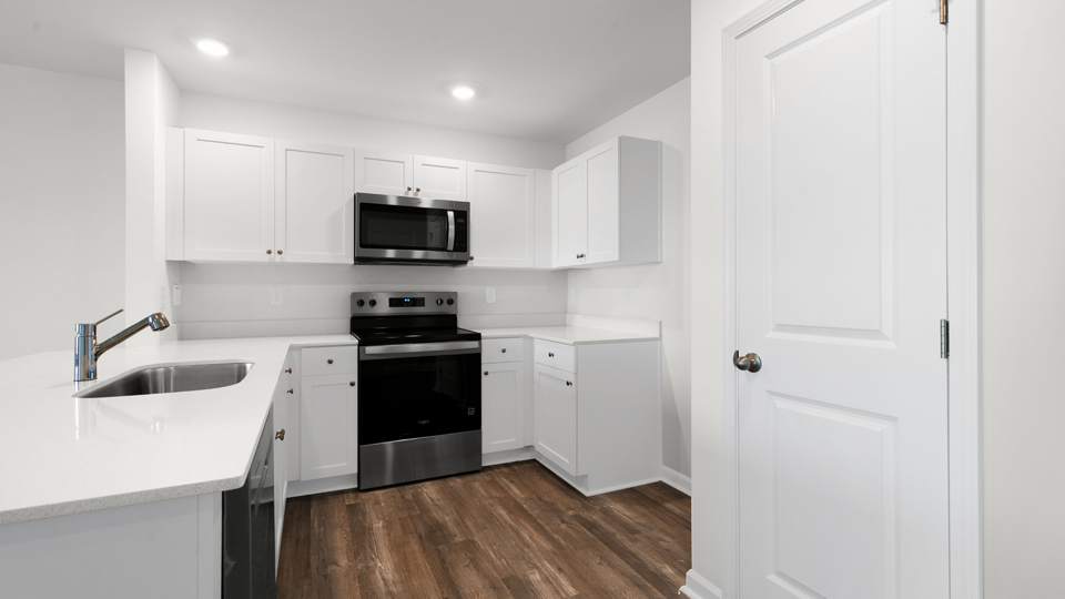 kitchen with quartz counters, kitchen island, pantry, stainless steel appliances